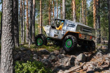 KARELIA, RUSSIA - CIRCA JUNE, 2022: Ladoga Gölü çevresindeki Off-road turnuvası Ladoga Kupası 2022. 4x4 Jeep arazi aracı ormanın ortasında kayaların üzerinden geçiyor.