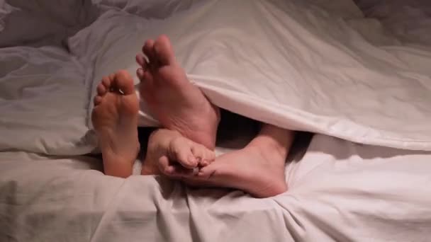 Пара Чоловічих Жіночих Ніг Ноги Весело Ються Під Ковдрою Аркуші — стокове відео