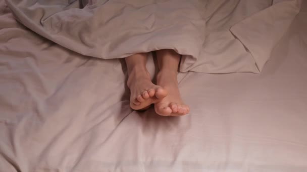 Kadın Ayakları Geceleri Beyaz Bir Çarşafın Üzerinde Battaniyenin Altında Uyurlarken — Stok video