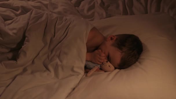 Der Kleine Junge Schläft Unruhig Und Umarmt Nachts Ein Teddybär — Stockvideo