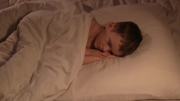 귀여운 소년은 저녁에 베개에 행복하게 자고있다 침실에서 침대에 — 비디오