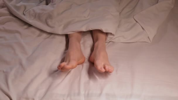 Женские Ноги Двигаются Сне Вечерам Одеялом Белом Листе Женщина Спит — стоковое видео
