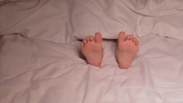 다리는 시트에 발가락으로 재미와 이동합니다 행복한 소녀는 침실에 침대에 편안한 — 비디오