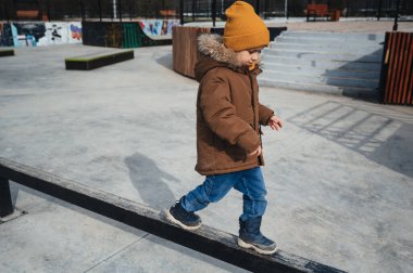 Anaokulu öğrencisi çocuk sonbaharda parkta oyun oynuyor.