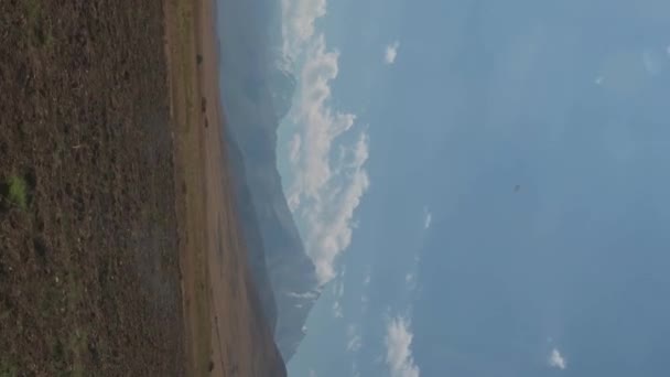 夏天的一天 哈萨克斯坦草原上的天山风景秀丽 公路上一辆行驶中的汽车拍摄的垂直慢镜头 — 图库视频影像
