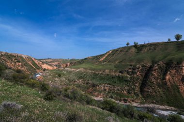 Baharda mavi gökyüzünün altında Kazakistan 'da Kanyon ve Aksu nehri manzarası