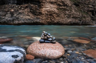 Kazakistan 'daki Aksu Kanyonu' ndaki dağlarda bir nehirdeki taşlar.