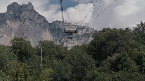 夏のクリミアのアイペトリ山脈の森の上にゆっくりと動く楽しい動きでケーブルカー — ストック動画