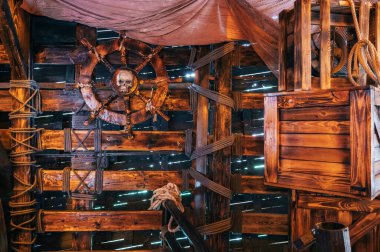 Eski bir ortaçağ korsan gemisindeki kaptan kabininin içi. Üzerinde korsan kafatası amblemi olan tahta bir direksiyon simidi var.