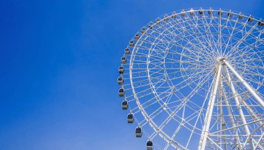 Beyaz büyük dönme dolap arka planda parlak mavi gökyüzü lunaparkta yazın fuarda fotokopi alanı ile birlikte