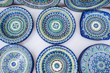 Özbekistan 'ın Taşkent kentindeki sofra eşyaları pazarında el yapımı geleneksel Asya desenli el yapımı Özbek seramik tabaklar
