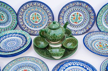 Özbek el yapımı seramik tabaklar ve el yapımı çaydanlık, Taşkent Özbekistan 'daki çömlekçilik atölyesinde geleneksel Asya desenine sahip.