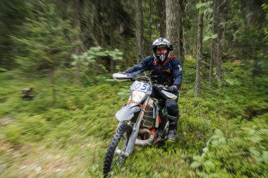 KARELİYA, RUSSIA REÜKLİK - CIRCA HAZİRAN 2022: Karelia 'da Ladoga Kupası 2022 off-road turnuvası. Motosiklet yarışçısı motorsiklet motosikletini hareket bulanıklığıyla zorlu arazide sürüyor.