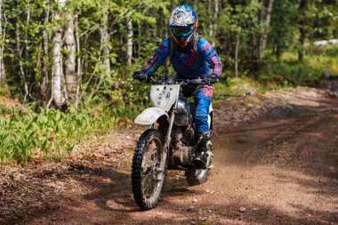 KARELİYA, RUSSIA REÜKLİK - CIRCA HAZİRAN 2022: Karelia 'da Ladoga Kupası 2022 off-road turnuvası. Dayanıklı spor motosikletli bir motosikletli motosikletli motosiklet yarışçısı bir ormanda yarışa katılır.