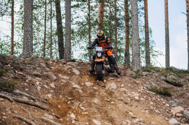 KARELİYA, RUSSIA REÜKLİK - CIRCA HAZİRAN 2022: Karelia 'da Ladoga Kupası 2022 off-road turnuvası. Bir off-road spor motosikletli motosikletli motosiklet yarışçısı orman yarış pistindeki bir kayaktan iniyor.