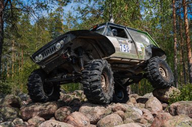 KARELIA, RUSSIA - CIRCA JUNE, 2022: Ladoga Gölü çevresindeki Off-road turnuvası Ladoga Kupası 2022. 4x4 SUV yazın doğada bir off-road yarışında kayaların üzerinden geçer.