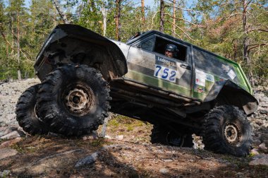 KARELIA, RUSSIA - CIRCA JUNE, 2022: Ladoga Gölü çevresindeki Off-road turnuvası Ladoga Kupası 2022. 4x4 SUV yazın doğada bir off-road yarışında kayaların üzerinden geçer.