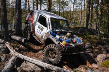 KARELIA, RUSSIA - CIRCA JUNE, 2022: Ladoga Gölü çevresindeki Off-road turnuvası Ladoga Kupası 2022. Niva 4x4 off-road arabaları ormanın ortasında kayalıklarda yarışır.