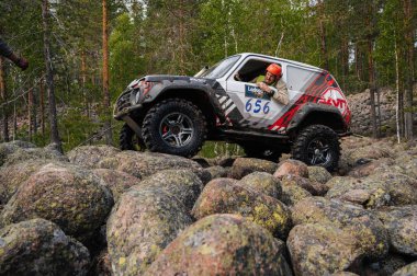 KARELIA, RUSSIA - CIRCA JUNE, 2022: Ladoga Gölü çevresindeki Off-road turnuvası Ladoga Kupası 2022. Off-road cipi Niva 4x4 araba doğada kayalıklarda yarışır.