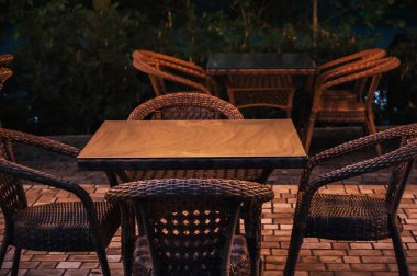 Akşam bir kafede ahşap masa ve eski hasır sandalyeler.