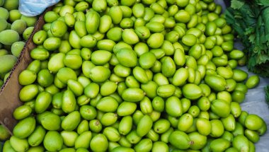 Özbekistan 'da bir pazarın tezgahında olgunlaşmamış yeşil kayısı. Pazar yerinde geleneksel Özbek yemekleri - yeşil uryuk, dovcha, gura