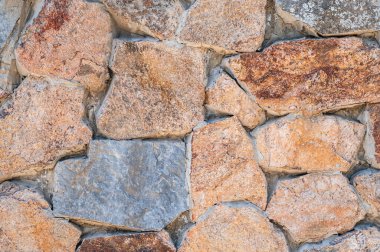 Çok renkli taşlardan yapılmış modern bir taş duvarın dokusu.