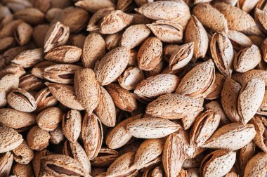 bir mağaza tezgahında desenli bir kabukta soyulmamış badem çekirdekleri ile arkaplan