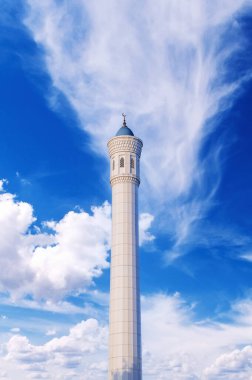 Özbekistan 'ın Taşkent kentindeki modern mermer İslami Küçük Cami' nin yüksek beyaz minaresi mavi gökyüzünün arka planında