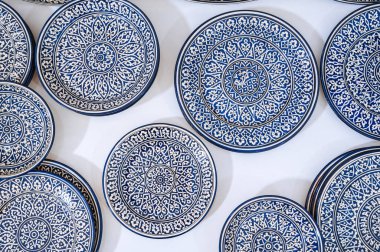 Özbekistan 'daki doğu sofra eşyaları pazarında elle boyanmış İslami arabesk desenli geleneksel Arapça Özbek seramik plakası