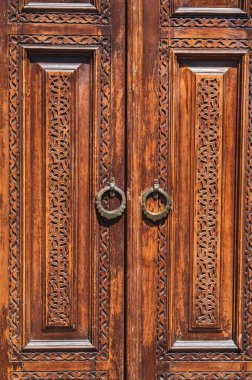 traditional Asian Uzbek patterns arabesque ornament on an ancient wooden carved door in Uzbekistan close-up clipart