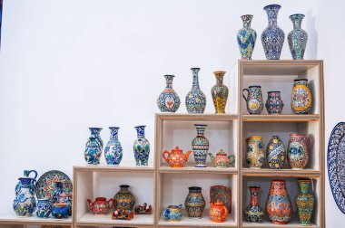 Özbek el yapımı seramik vazolar ve el boyaması geleneksel Asya kalıplarıyla birlikte doğu sofra eşyaları mağazasındaki raflarda