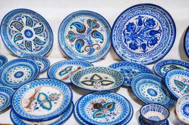 Özbek el yapımı seramik tabaklar ve Taşkent Özbekistan 'daki masa eşyaları mağazasında el boyaması geleneksel Asya kökenli mavi desenler.