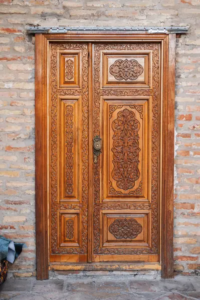 stock image modern carved wooden doors with tajik carved pattern with Islamic ornament in oriental kandakori style in Tadjikistan