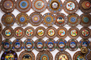 Özbekistan 'ın hediyelik eşya dükkanında elle boyanmış, ahşap oymalı el yapımı Özbek ahşap hediye tabakları.