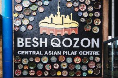 Geleneksel Özbek süsüsüyle süslenmiş Orta Asya Pilaf Merkezi Besh Qozon 'un reklam levhası. Taşkent, Özbekistan - 16 Nisan 2024