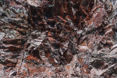 Turuncu taştan bir dağın doğal mineralleri yakın planda.