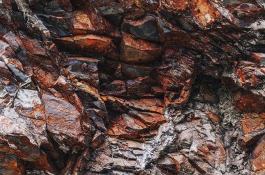 Turuncu taştan bir dağın doğal mineralleri yakın planda.