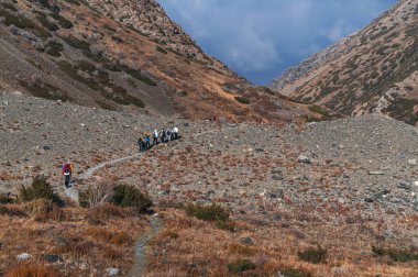 Bir grup turistin sonbahar portakal vadisinde sonbaharda dağlarda gezdiği manzara.