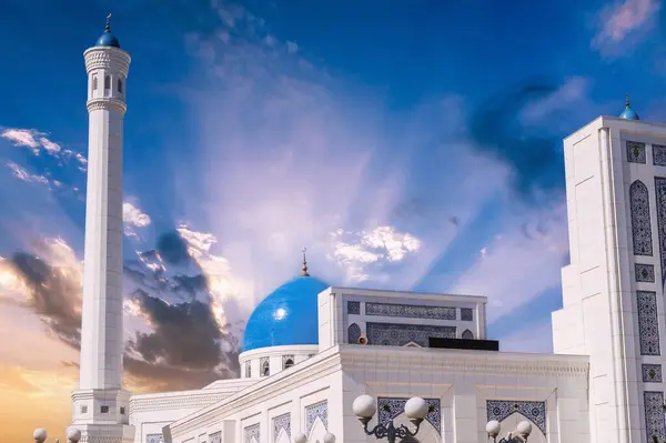 stock image white minaret and blue dome of marble Islamic Masjid Minor Mosque in Tashkent in Uzbekistan on background of the sunrise sky