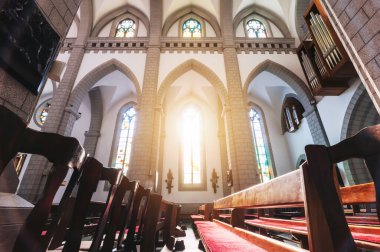 Kilise sıraları ve güneş ışığı olan bir Hıristiyan Katolik kilisesinin içinde. Özbekistan 'daki Taşkent' te İsa 'nın Kutsal Kalbi Katedrali