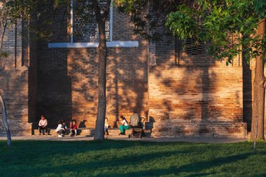 Özbek çocuklar baharda Barak Khan medresesinin duvarlarının yanında yürürler ve oynarlar. Taşkent, Özbekistan - 17 Nisan 2024