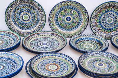 Özbekistan 'daki çömlek atölyesinde elle boyanmış İslami arabesk desenli Arapça Özbek seramik plakası