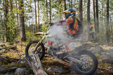 KARELİYA, RUSSIA REÜKLİK - CIRCA HAZİRAN 2022: Karelia 'da Ladoga Kupası 2022 off-road turnuvası. Motosiklet yarışçısı motorsiklet yarışında aşırı ısınmış bir motorla spor motosiklet sürüyor.