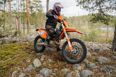 KARELİYA, RUSSIA REÜKLİK - CIRCA HAZİRAN 2022: Karelia 'da Ladoga Kupası 2022 off-road turnuvası. Spor off-road motosiklet yarışçısı zorlu orman yarış pistinde
