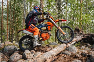 KARELİYA, RUSSIA REÜKLİK - CIRCA HAZİRAN 2022: Karelia 'da Ladoga Kupası 2022 off-road turnuvası. Spor off-road motosiklet yarışçısı zorlu orman yarış pistinde