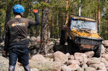 KARELIA, RUSSIA - CIRCA JUNE, 2022: Ladoga Gölü çevresindeki Off-road turnuvası Ladoga Kupası 2022. 4x4 Mercedes off-road yarışında kayaların üzerinden geçiyor.