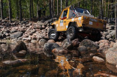 KARELIA, RUSSIA - CIRCA JUNE, 2022: Ladoga Gölü çevresindeki Off-road turnuvası Ladoga Kupası 2022. 4x4 Mercedes yazın doğada bir off-road yarışında kayaların üzerinden geçiyor.