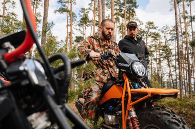 KARELİYA, RUSSIA REUKLİK - CIRCA HAZİRAN, 2022: Ladoga Gölü çevresindeki off-road turnuvası Ladoga Kupası 2022. Yarışçıyla mekanik olarak yarışmadan önce motoru tamir eder ve ayarlar.