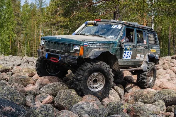 KARELIA, RUSSIA - CIRCA JUNE, 2022: Ladoga Gölü çevresindeki Off-road turnuvası Ladoga Kupası 2022. 4x4 SUV yazın doğada bir off-road yarışında kayaların üzerinden geçer.