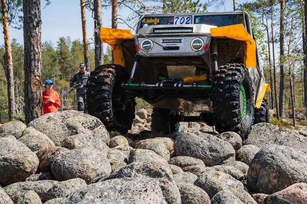 KARELIA, RUSSIA - CIRCA JUNE, 2022: Ladoga Gölü çevresindeki Off-road turnuvası Ladoga Kupası 2022. 4x4 Jeep arazi aracı ormanın ortasında kayaların üzerinden geçiyor.